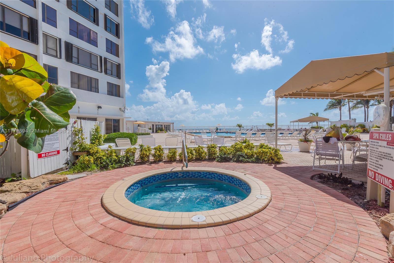 A circular hot tub sits on a brick patio next to a tall building — 3505 S Ocean Dr # 504, Hollywood FL 33019, HOLLYWOOD, FL