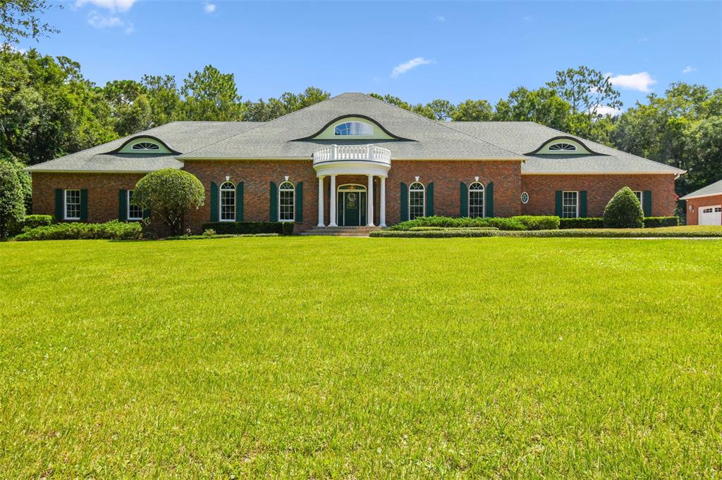 A single-story brick house with a central portico and three dormer windows on the roof — 1745 TAYLOR WOODS ROAD, DELAND, FL