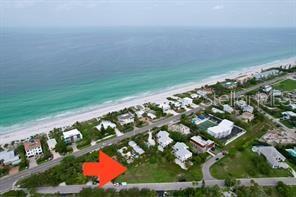 An aerial view shows a vacant grassy lot near a beach and coastal road — 521 NEPTUNE AVENUE, LONGBOAT KEY, FL