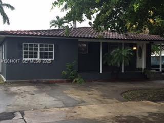 A dark-colored single-story house is partially obscured by trees and palm trees — 335 NE 114th St, Miami FL 33161, MIAMI, FL