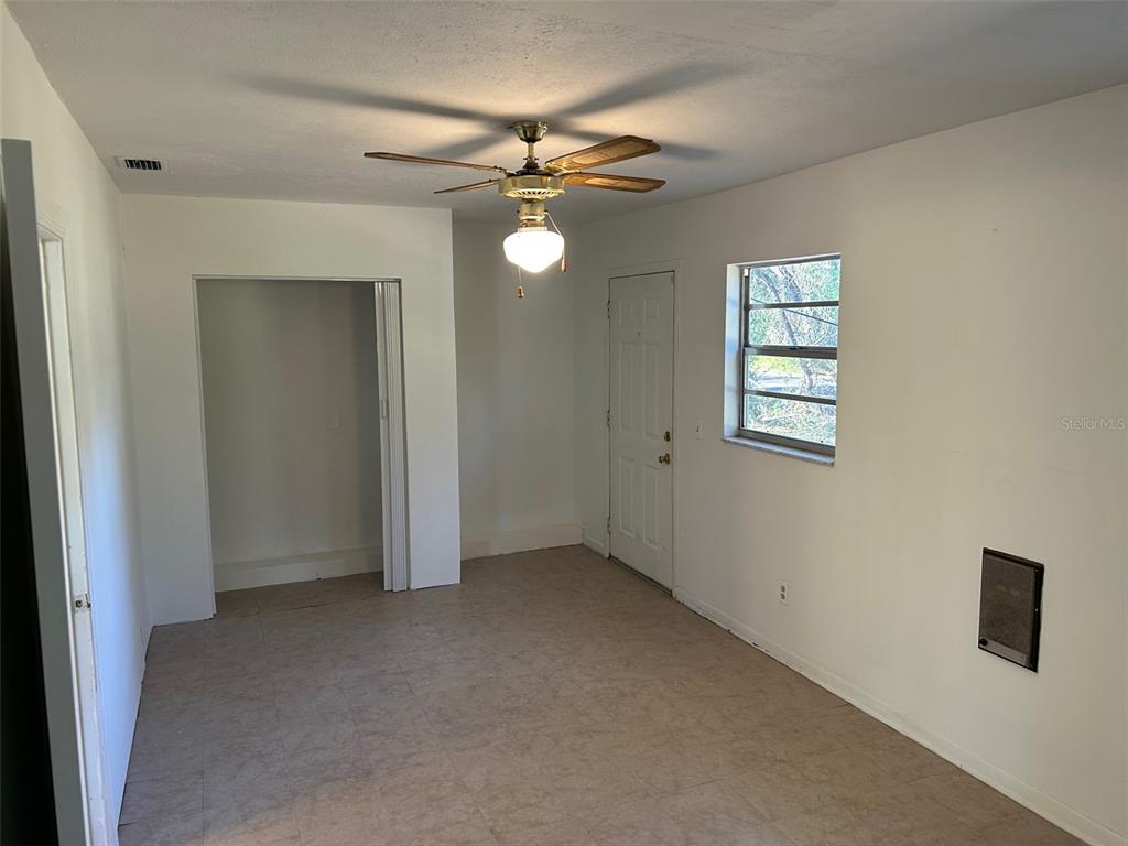 An empty room features white walls, tile flooring, a ceiling fan, and a closet — 7001 32ND AVENUE S, TAMPA, FL