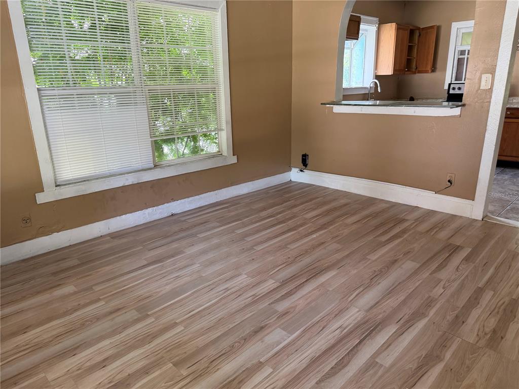 A room with light wood-look flooring, tan walls, and a window with white blinds — 444 AVENUE B NE, WINTER HAVEN, FL
