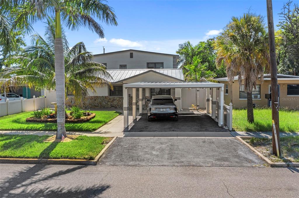 A single-story house with a metal roof, a carport, and a stone-accented front facade — 2035 28TH STREET S, ST PETERSBURG, FL