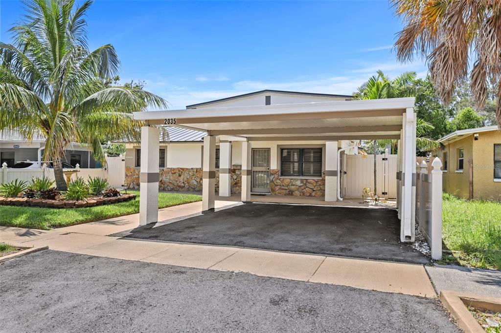 A single-story house with a stone facade and a large attached carport in the front — 2035 28TH STREET S, ST PETERSBURG, FL