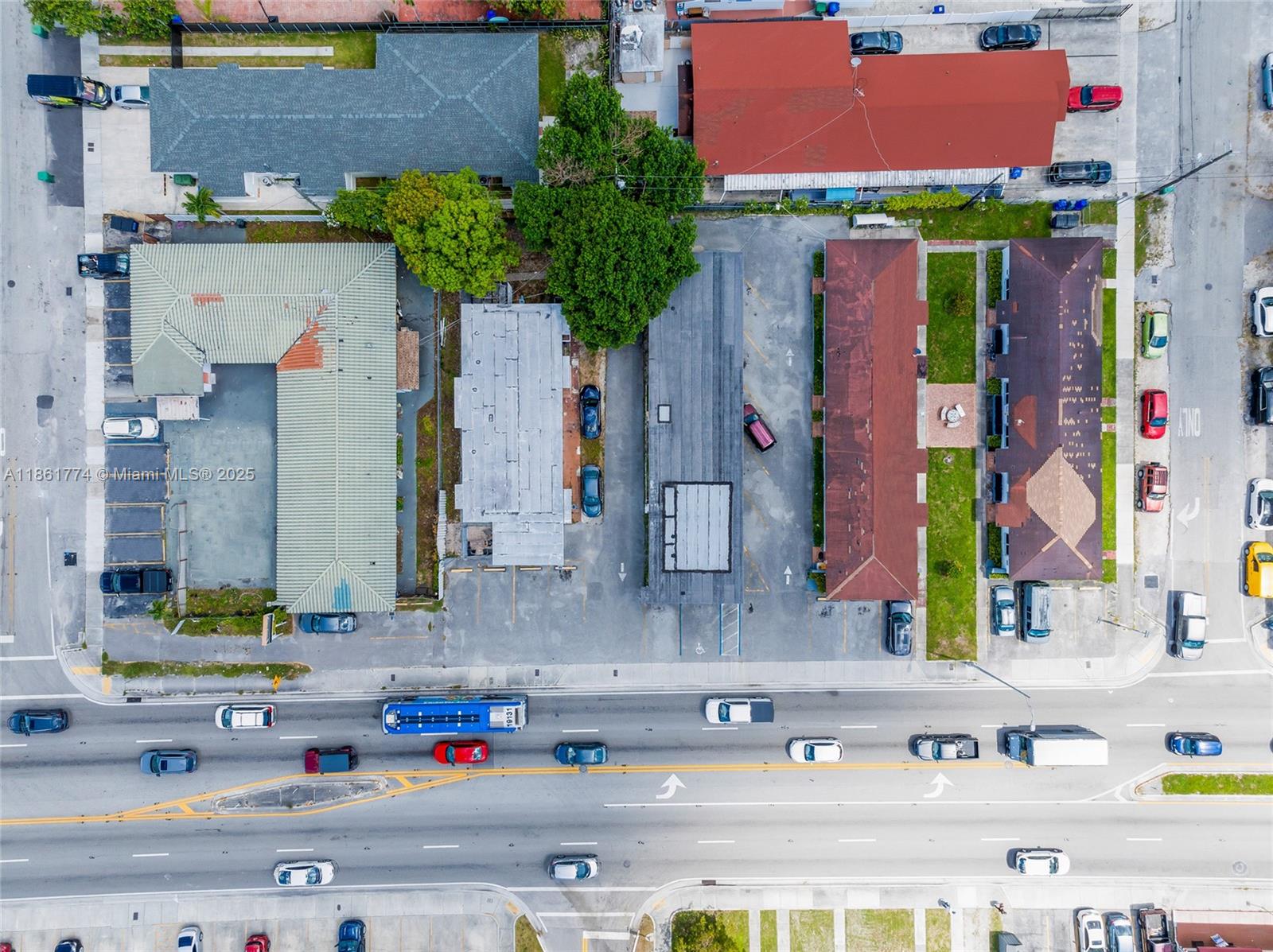 This aerial view shows several commercial buildings with parking lots situated along a busy road — 4831 W Flagler St, Miami FL 33134, MIAMI, FL