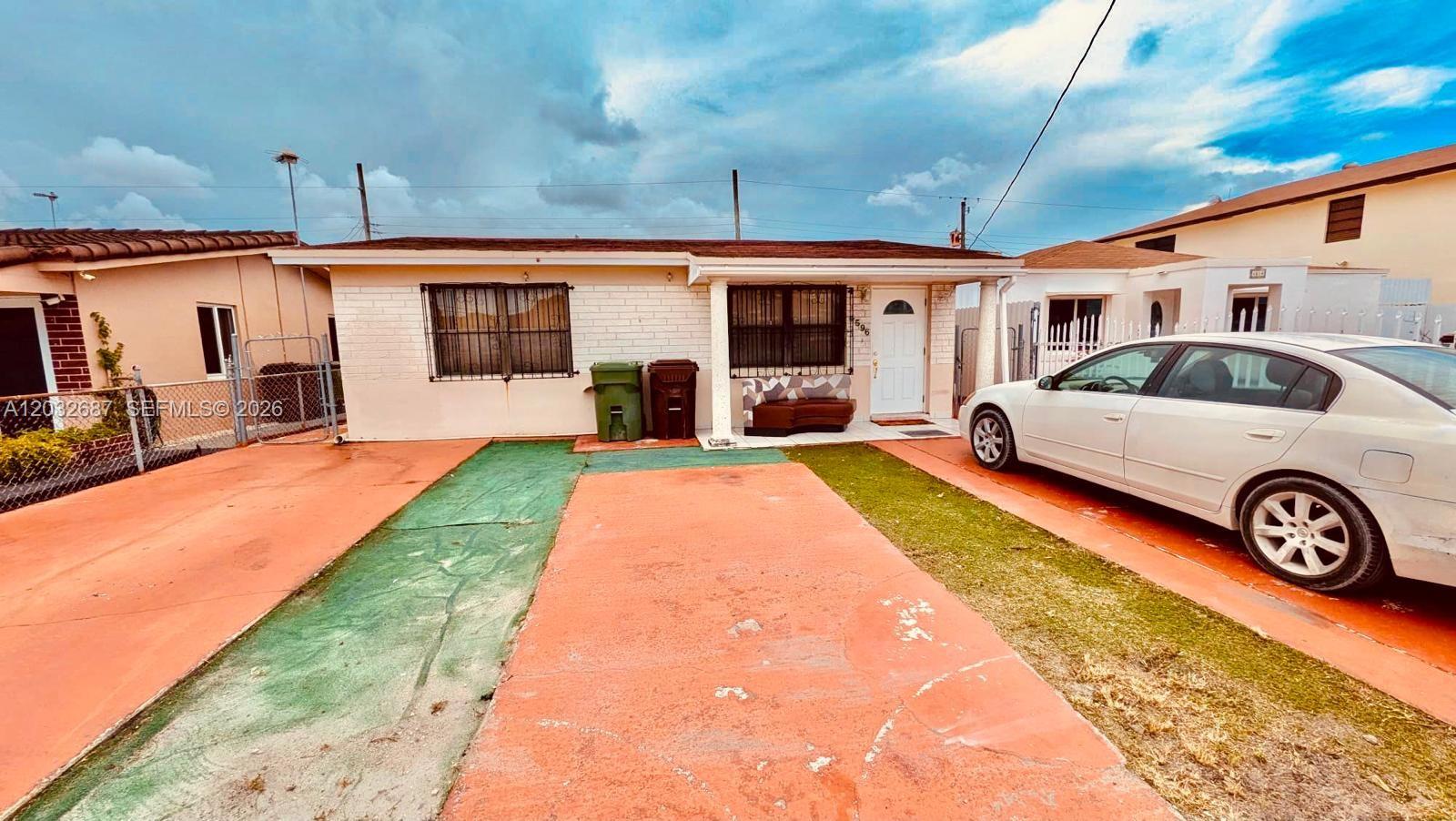 A single-story house with a white brick facade, a front porch, and a paved driveway — 4596 E 8th Ct, Hialeah FL 33013, HIALEAH, FL