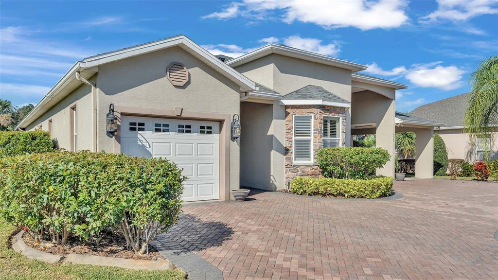 A single-story house with a paved driveway, a garage, and a stone-accented bay window — 402 CRUISERS DRIVE, POLK CITY, FL