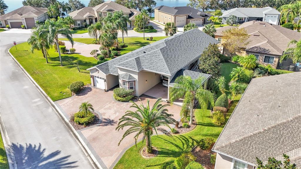 An aerial view shows a suburban house with a paved driveway, palm trees, and landscaping — 402 CRUISERS DRIVE, POLK CITY, FL