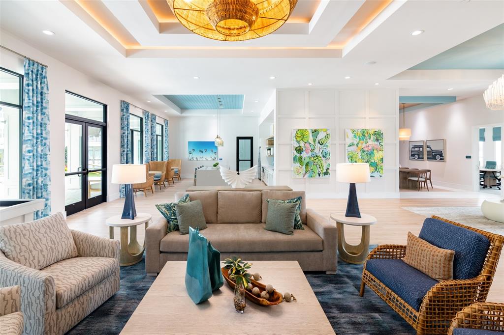 A bright, open-concept living area features a beige sofa, wicker chairs, and coastal-inspired decor — 100 WINDFLOWER LANE UNIT B2, DAYTONA BEACH, FL