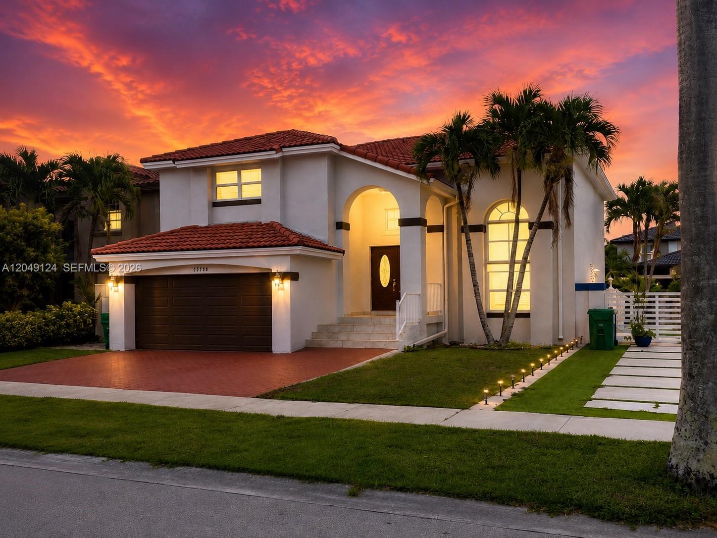 A two-story house with a red tile roof, white stucco exterior, and a sunset sky — 12948 NW 10th St, Miami FL 33182, MIAMI, FL
