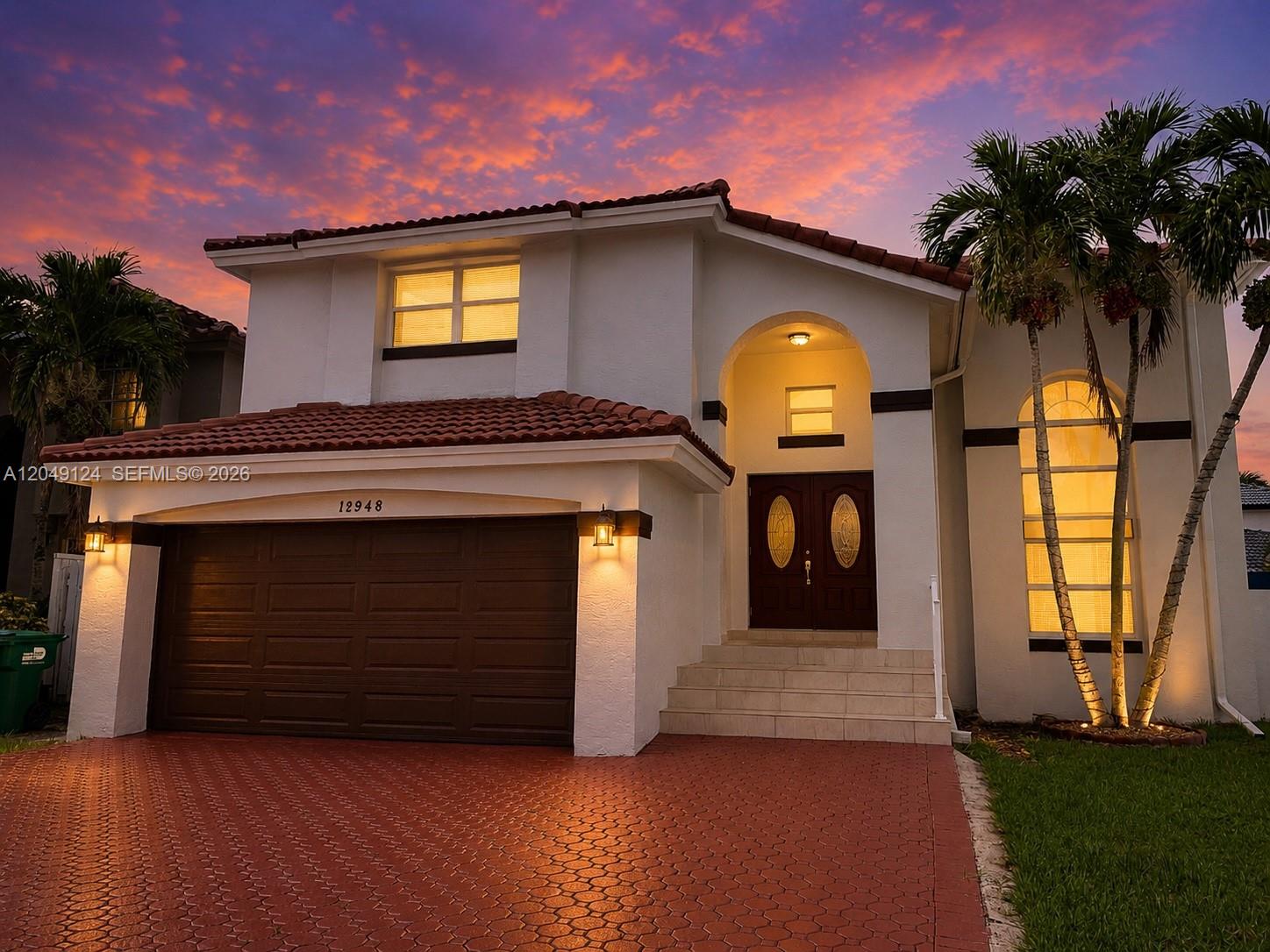 A two-story house with a red-tiled roof, white stucco exterior, and a paved driveway — 12948 NW 10th St, Miami FL 33182, MIAMI, FL