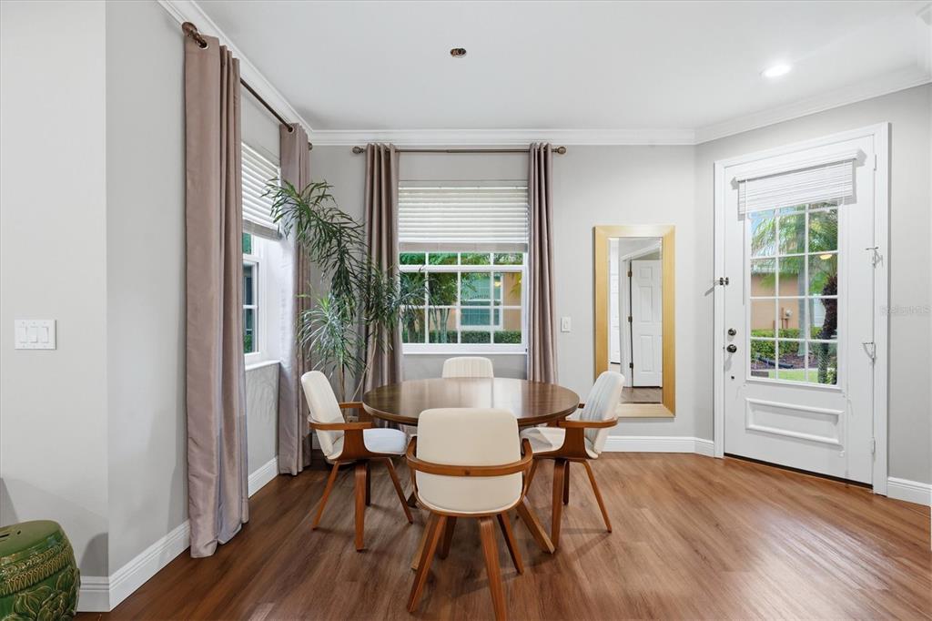 A dining area features a round wooden table, four chairs, a mirror, and a glass door — 11447 52ND COURT E, PARRISH, FL