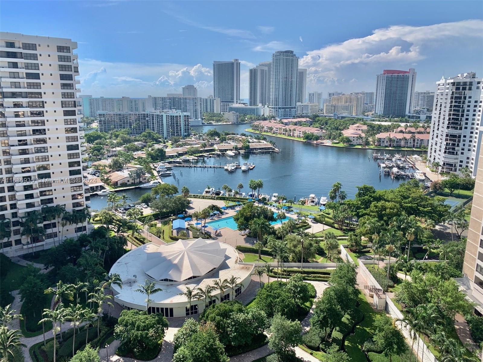 An elevated view shows a waterfront residential complex with a pool, marina, and city skyline — 600 Three Islands Blvd # 1817, Hallandale Beach FL 33009, HALLANDALE BEACH, FL