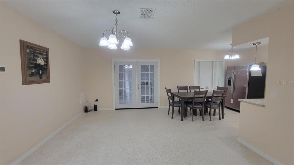 A dining area features a chandelier, a table with six chairs, and French doors — 3820 S ALPINE AVENUE, INVERNESS, FL