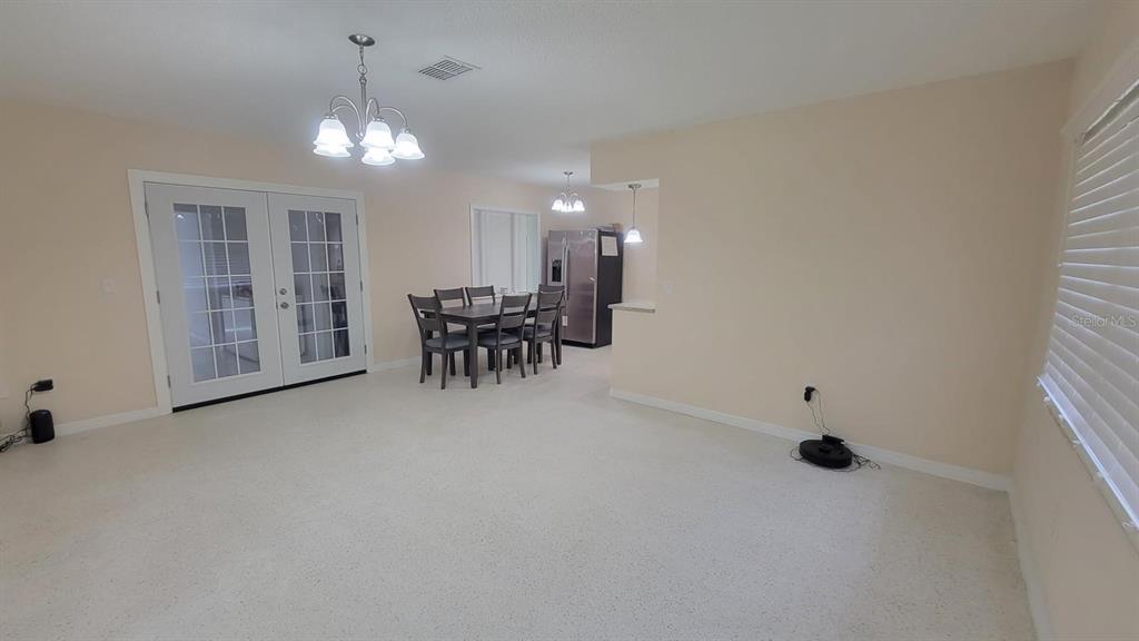 A dining area with a table and chairs sits adjacent to a kitchen and patio doors — 3820 S ALPINE AVENUE, INVERNESS, FL