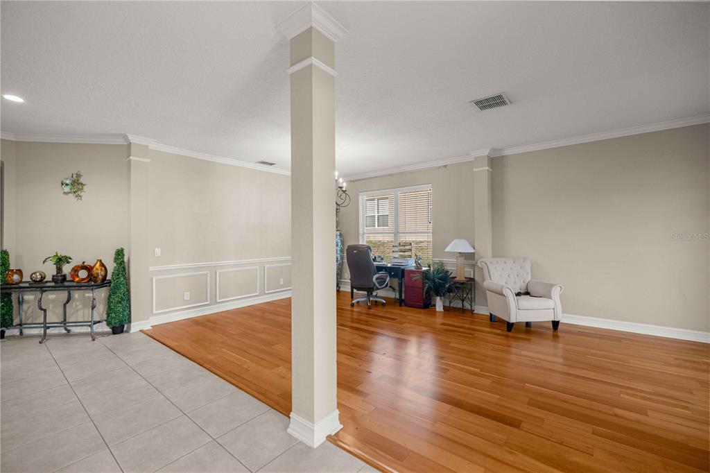 A room with hardwood floors, a central pillar, and a desk area near a window — 1271 LATTIMORE DRIVE, CLERMONT, FL
