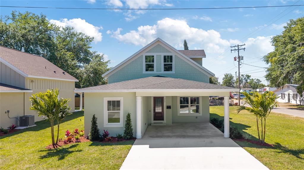A two-story light green house with a front porch, carport, and a concrete driveway — 25 EDWARDS STREET, PLANT CITY, FL