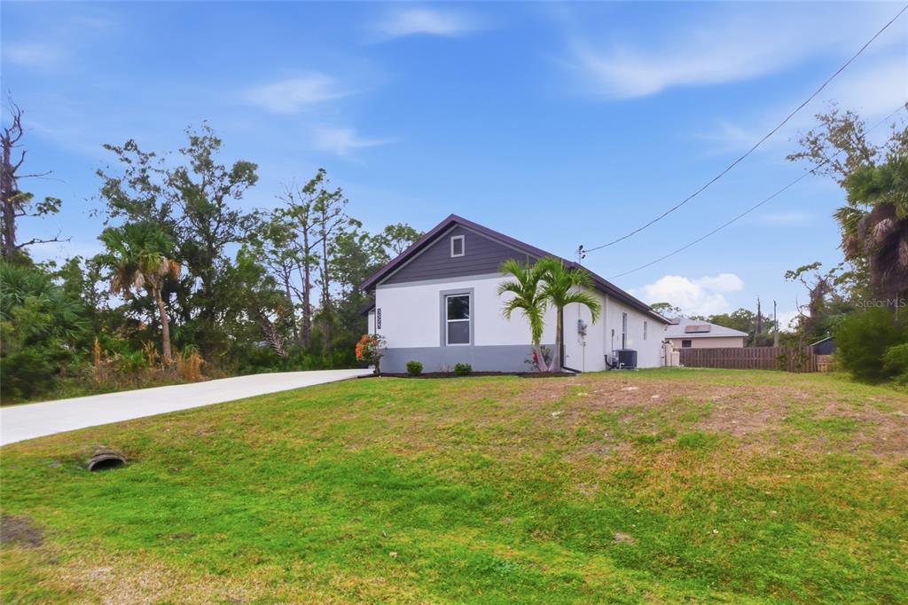 A single-story house with a white stucco exterior and a dark gray gable roof — 3373 EAGLE PASS STREET, NORTH PORT, FL