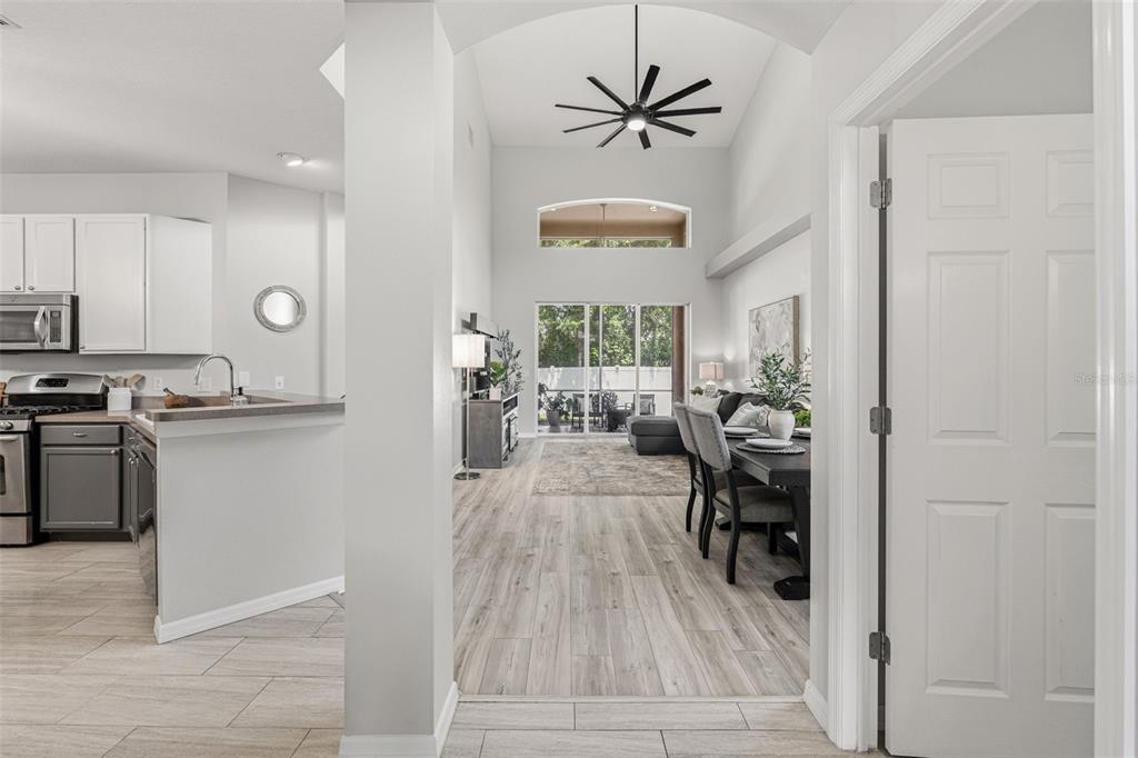A view from a doorway looking into an open-concept living area with vaulted ceilings — 11809 ACORN WOODS TERRACE, LAKEWOOD RANCH, FL