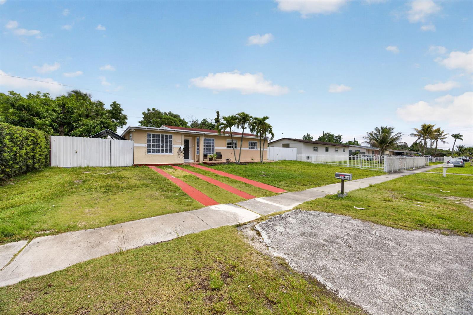 A single-story house with a red-striped driveway and palm trees in the front yard — 11751 SW 185th Terrace, Miami FL 33177, MIAMI, FL