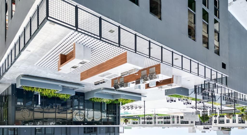 An outdoor rooftop terrace features a long kitchen island with grills and seating areas — 434 N ORANGE AVENUE, ORLANDO, FL