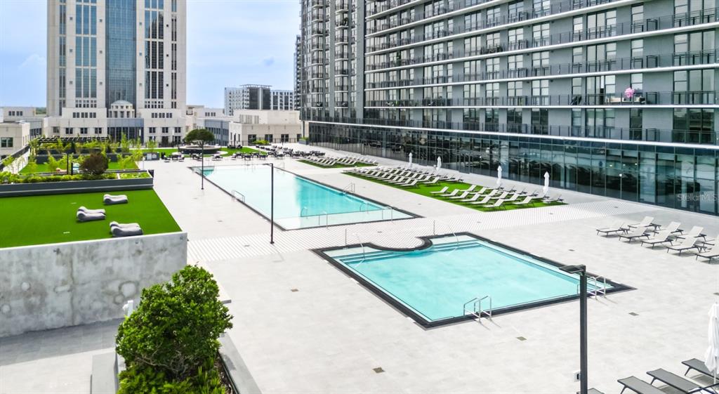 An elevated view of a modern apartment complex pool deck with two swimming pools — 434 N ORANGE AVENUE, ORLANDO, FL