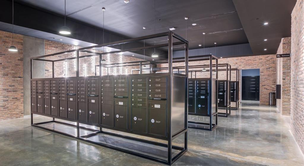A mailroom features rows of metal mailboxes set within black frames against exposed brick walls — 434 N ORANGE AVENUE, ORLANDO, FL