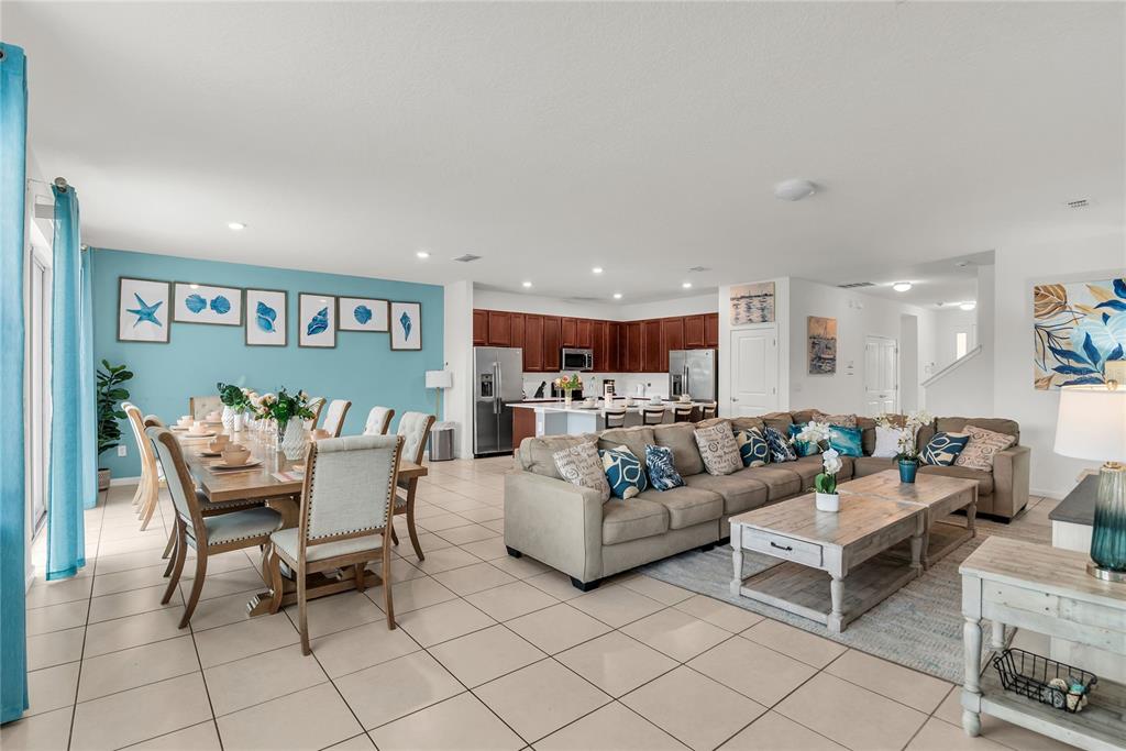 An open-concept living and dining area features tile floors, a blue accent wall, and cabinetry — 2576 SHANTI DRIVE, KISSIMMEE, FL