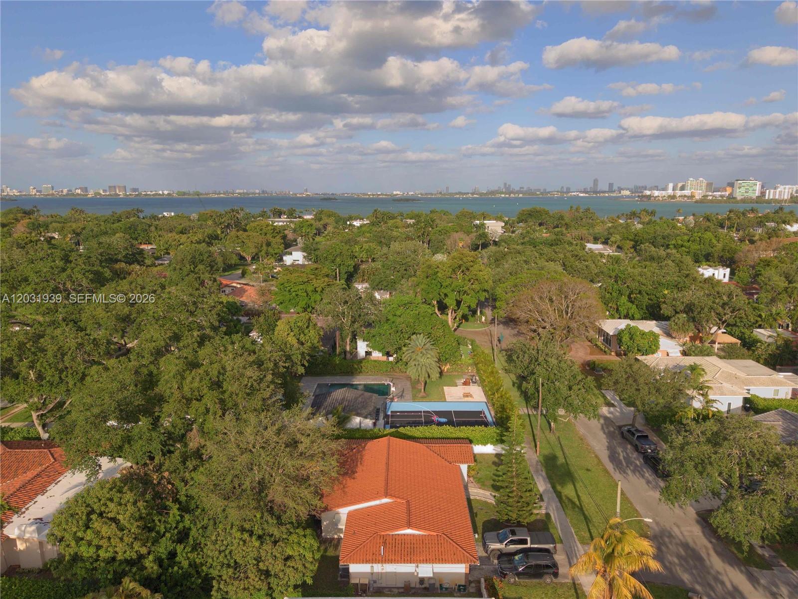 An aerial view shows a residential neighborhood with a house featuring a red-tiled roof — MIAMI SHORES, FL