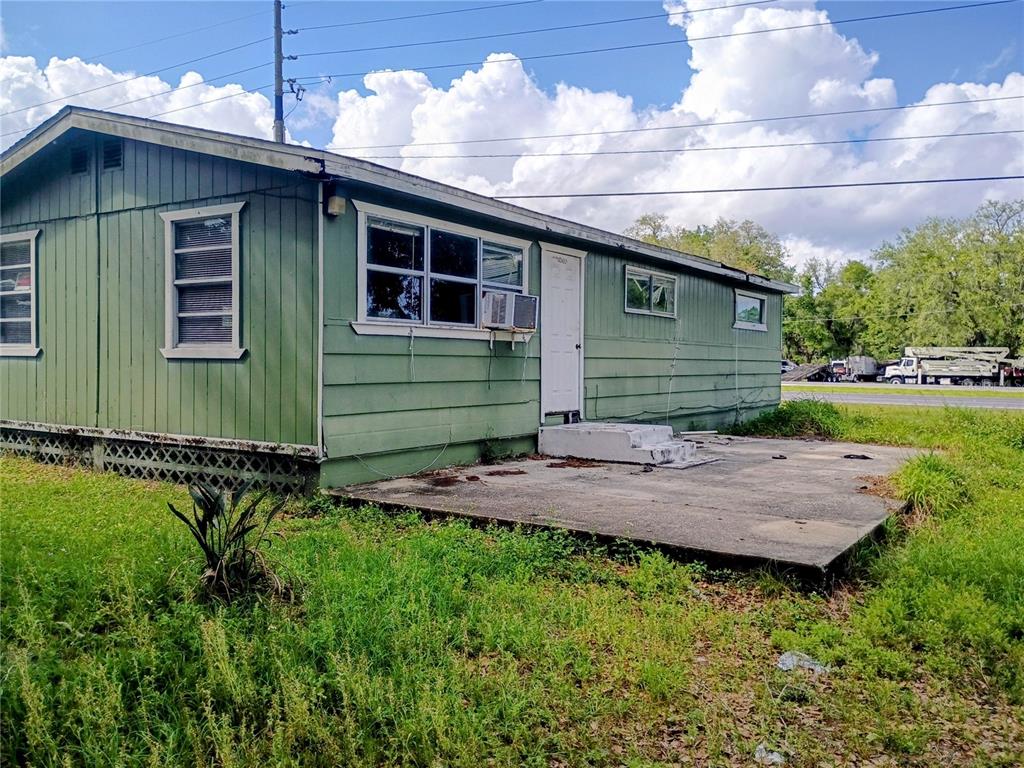An exterior view of a green, single-story manufactured home with a concrete patio — 4315 LAKE AVENUE, KISSIMMEE, FL