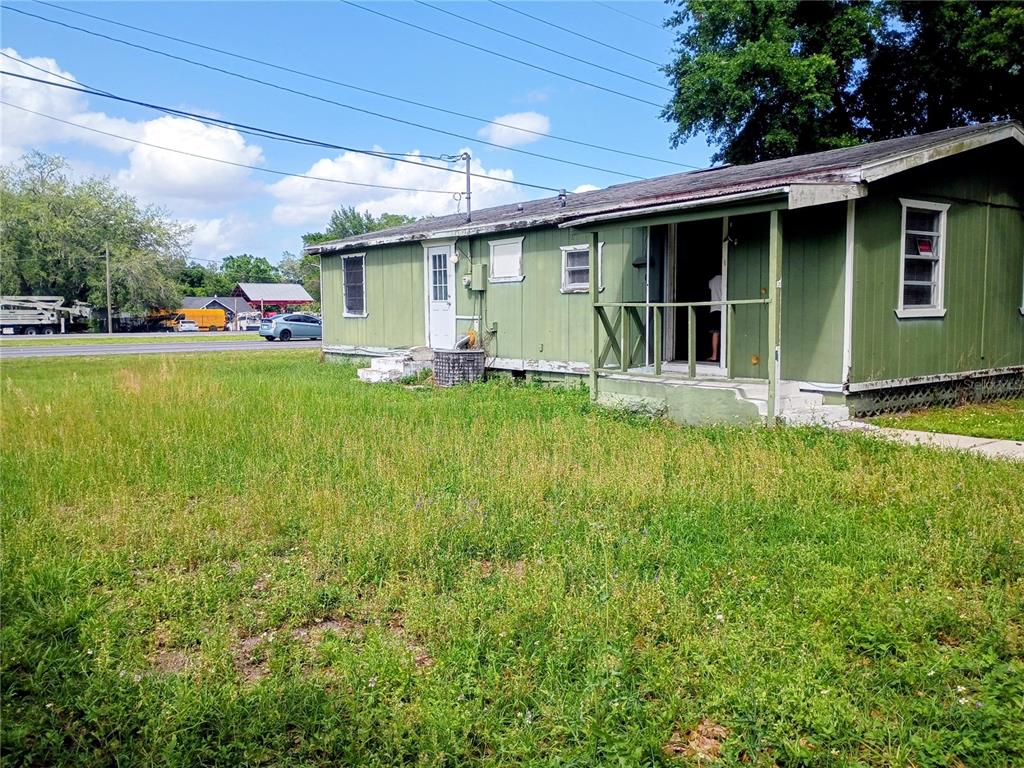 A green, single-story house with a porch sits on a grassy lot near a road — 4315 LAKE AVENUE, KISSIMMEE, FL