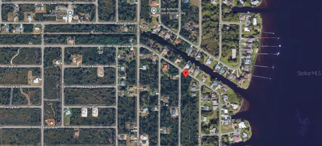 This is an aerial map showing a vacant lot marked with a pin near water — 3428 LINDGREEN STREET, PORT CHARLOTTE, FL