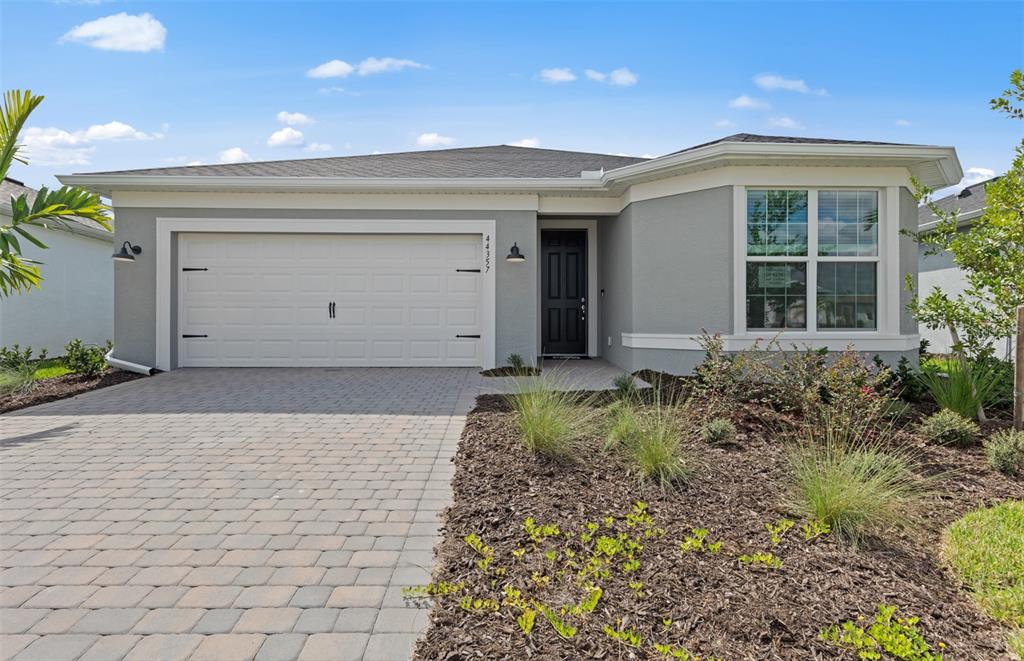 A single-story gray house with a two-car garage and a paved driveway — 16335 LILLY ELAINE WAY, BRADENTON, FL