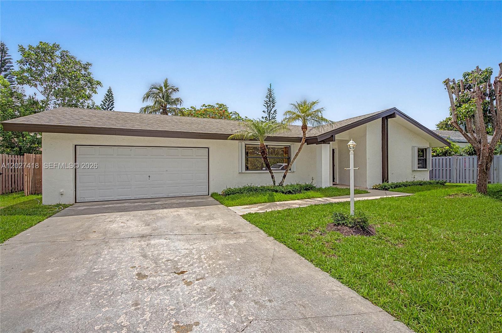 A single-story white house with a two-car garage and a concrete driveway — 10711 SW 116th Ave, Miami FL 33176, MIAMI, FL