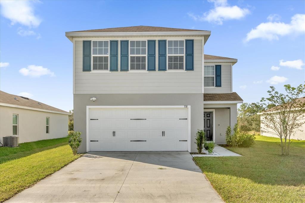 An aerial view shows a row of suburban houses facing a large, open grassy field — 718 EAGLE LANDING BOULEVARD, WINTER HAVEN, FL