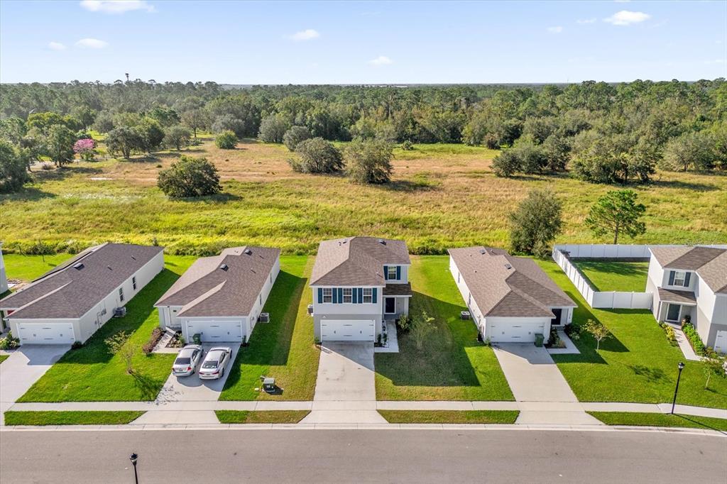 A kitchen features dark cabinets, granite countertops, a center island with stools, and stainless appliances — 718 EAGLE LANDING BOULEVARD, WINTER HAVEN, FL