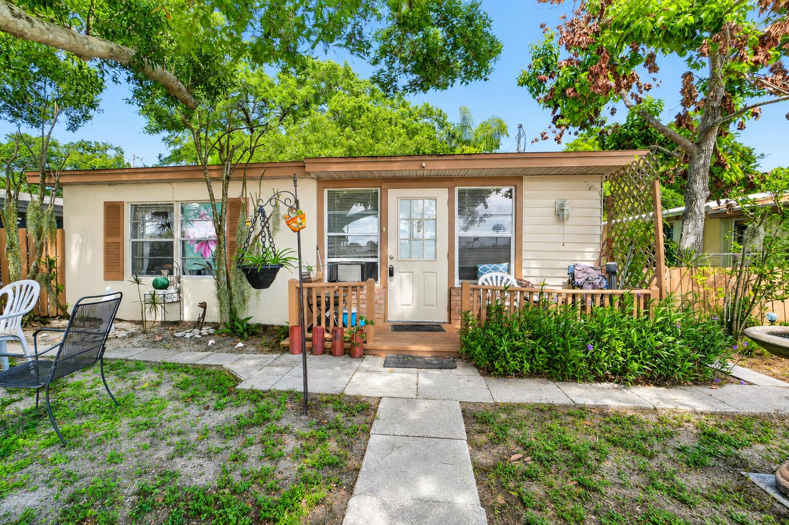 A single-story house with beige siding, a small wooden porch, and a stone walkway — 2666 12th Avenue, Vero Beach FL 32960, VERO BEACH, FL