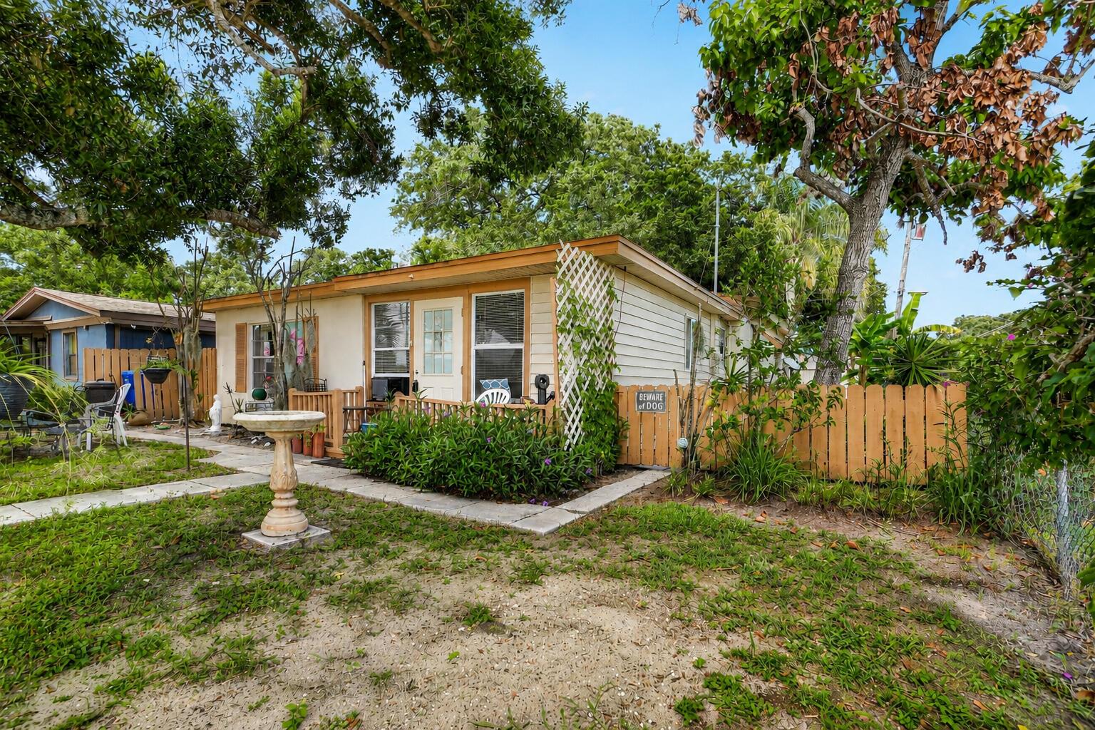A small, single-story house with a wooden fence, a birdbath, and a front porch — 2666 12th Avenue, Vero Beach FL 32960, VERO BEACH, FL