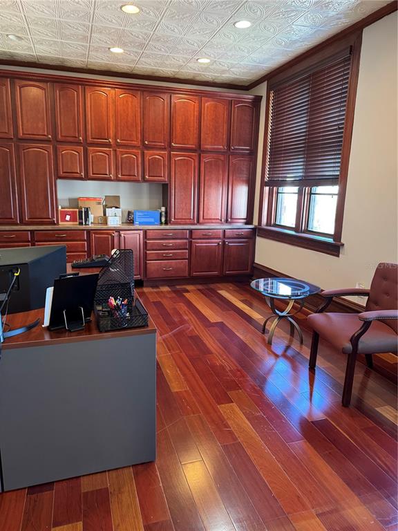 A home office features cherry-toned cabinetry, hardwood flooring, and a decorative tin ceiling — 44 SE 1ST AVENUE, OCALA, FL