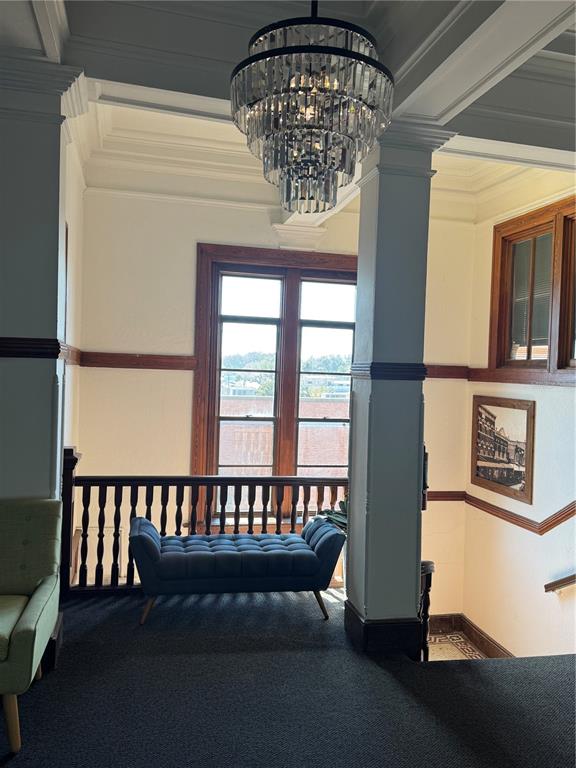 A landing area features a crystal chandelier, a tufted blue bench, and wooden trim — 44 SE 1ST AVENUE, OCALA, FL