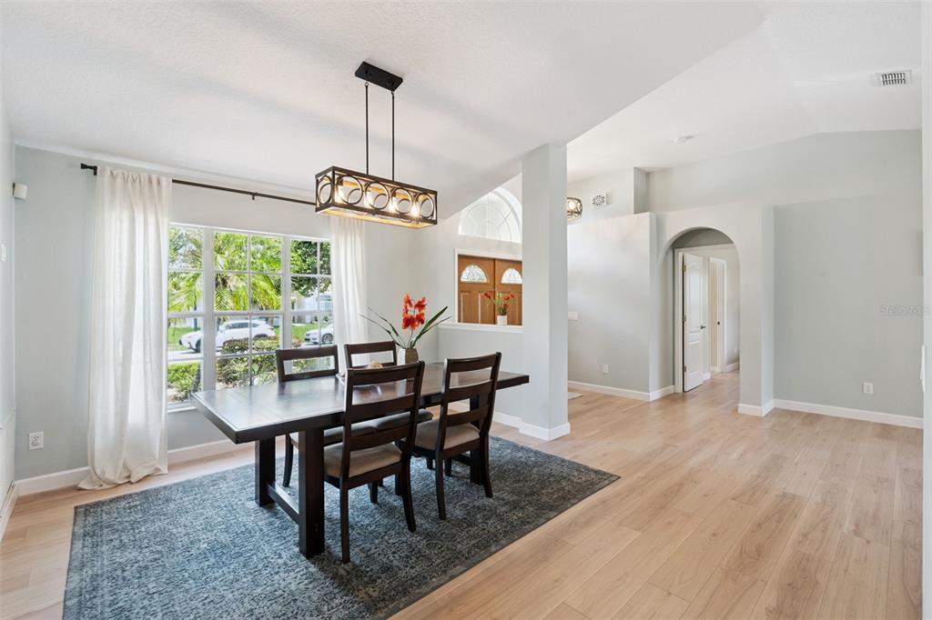 A dining room with a dark wood table, chairs, and a rectangular pendant light fixture — 14975 FAVERSHAM CIRCLE, ORLANDO, FL