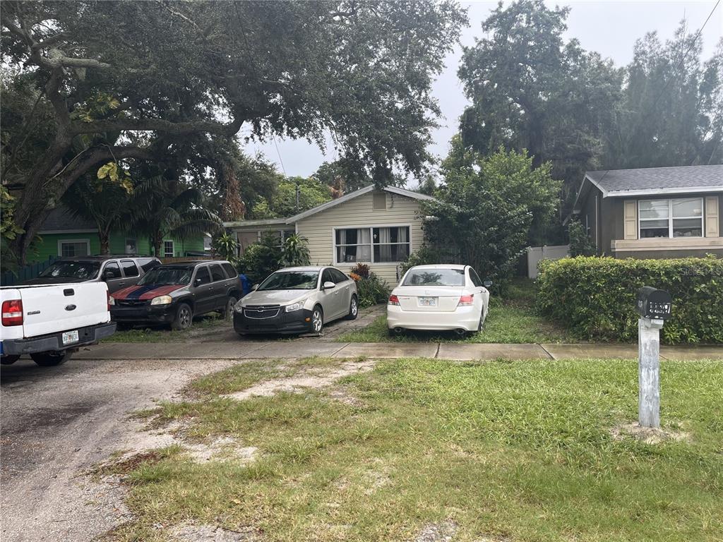 A single-story house with four cars parked in the driveway and front yard — 1127 AUBURN STREET, CLEARWATER, FL