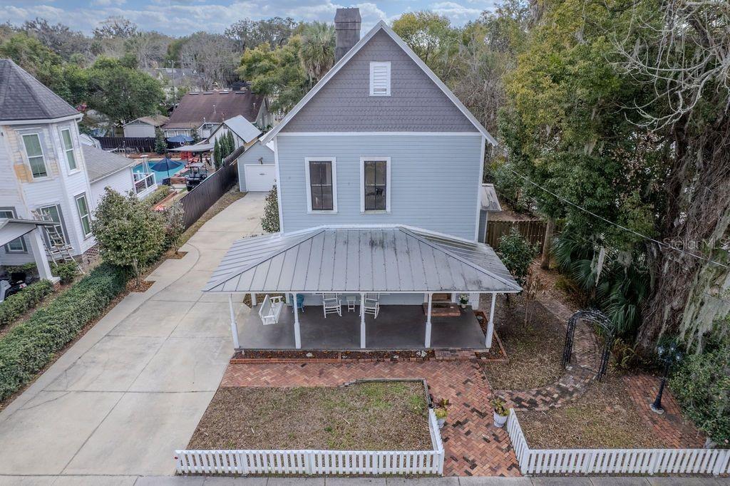 An aerial view of a two-story light blue house with a metal-roofed front porch — 720 SE 3RD STREET, OCALA, FL