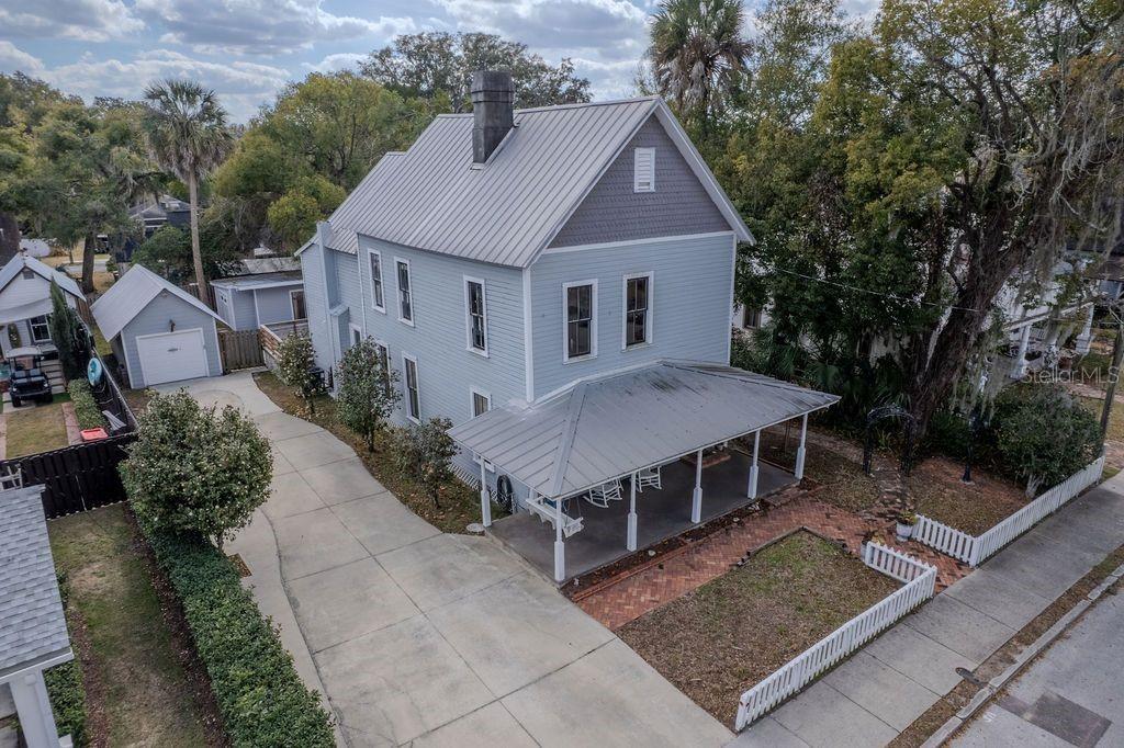 An aerial view of a two-story light blue house with a metal roof and porch — 720 SE 3RD STREET, OCALA, FL