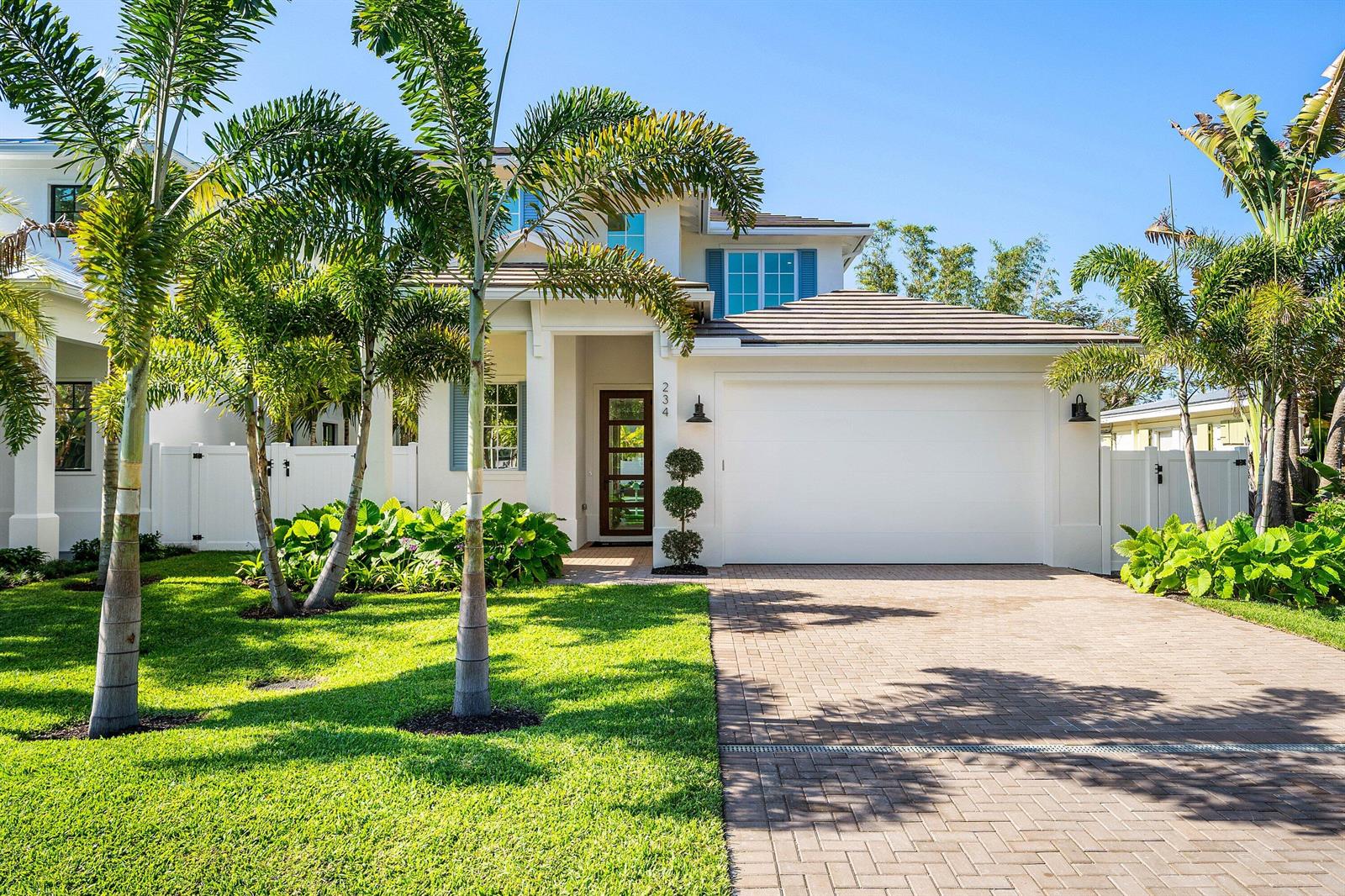 A two-story white house with a paved driveway, palm trees, and a front-facing garage — 234 NE 12th Street, Delray Beach FL 33444, DELRAY BEACH, FL