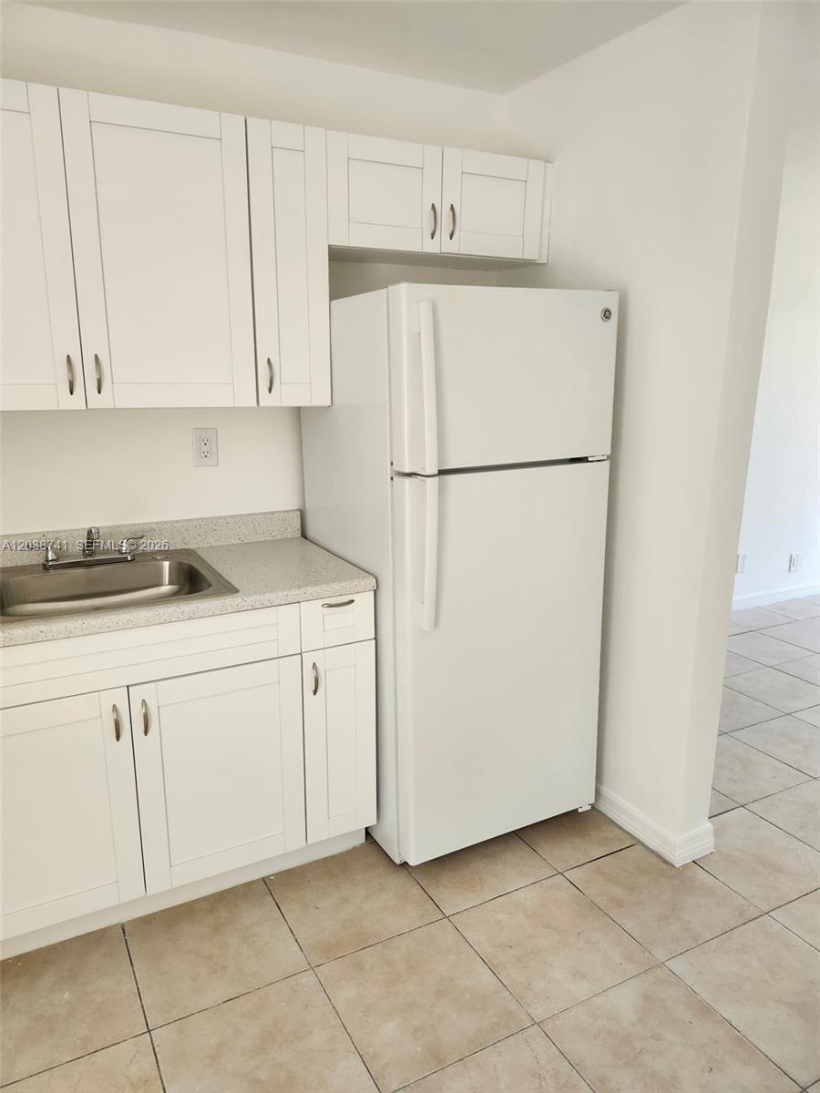 A kitchen features white cabinets, a stainless steel sink, and a white refrigerator — 726 21st St # 3, West Palm Beach FL 33407, WEST PALM BEACH, FL