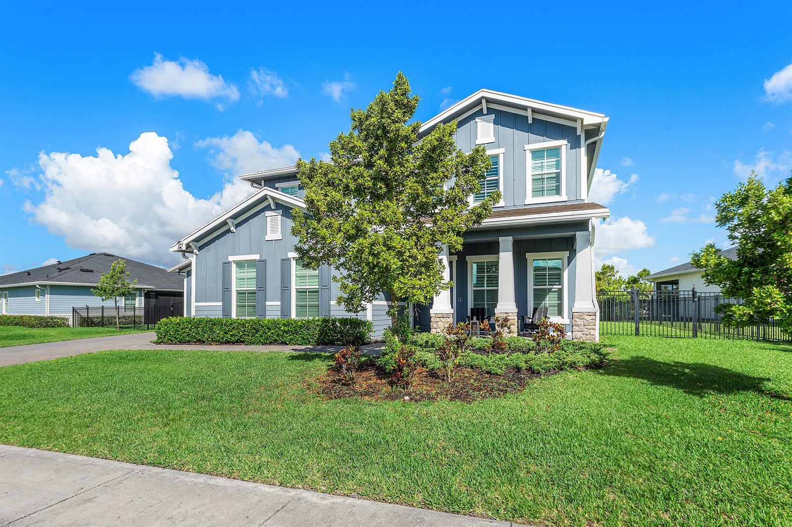 A two-story blue house with a white garage, front porch, and manicured lawn — 981 Castaway Court, Loxahatchee FL 33470, LOXAHATCHEE, FL