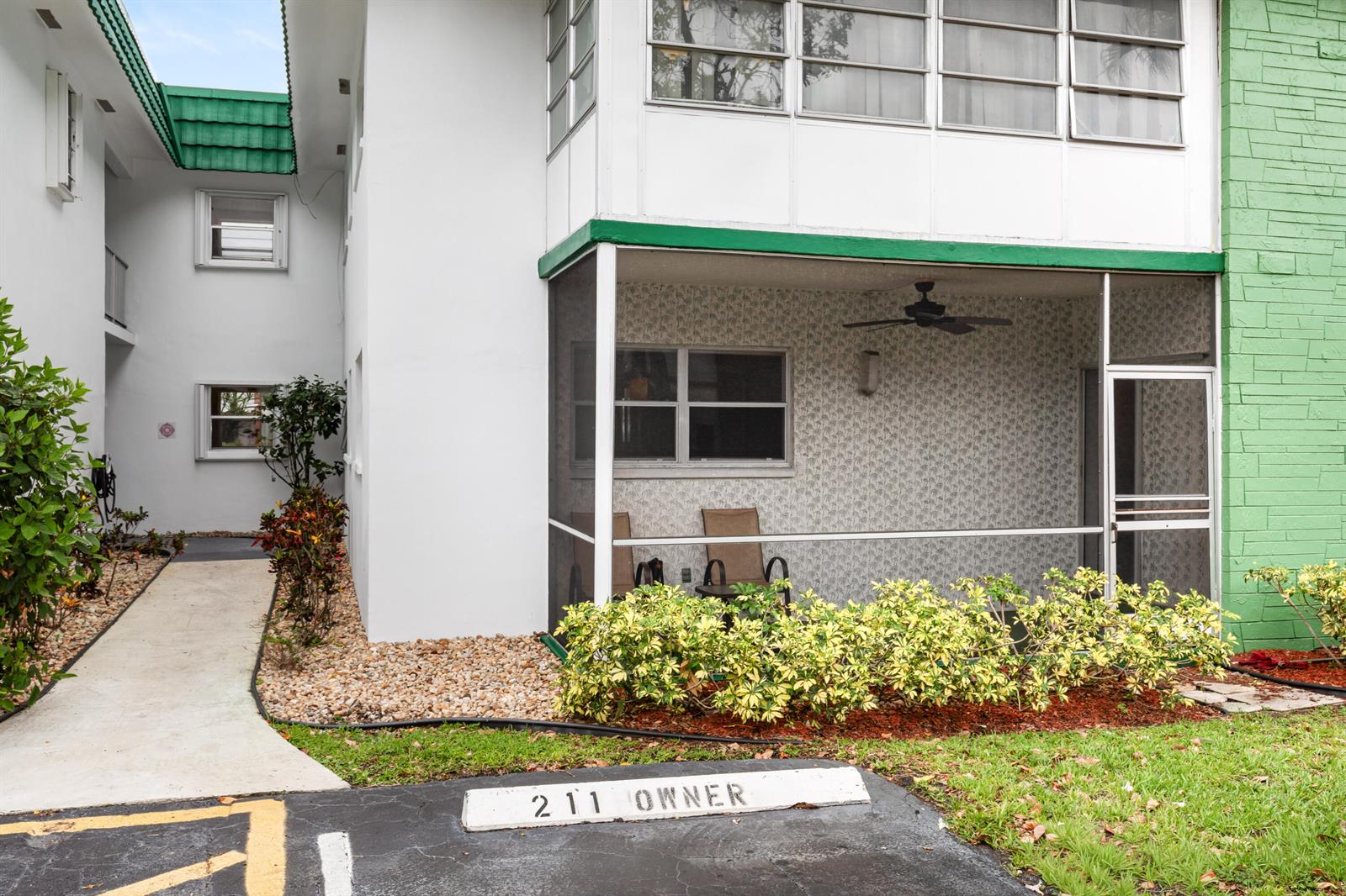An exterior view of a ground-floor apartment with a screened-in patio and assigned parking — 2271 NW 48th Terrace # 111, Lauderhill FL 33313, LAUDERHILL, FL