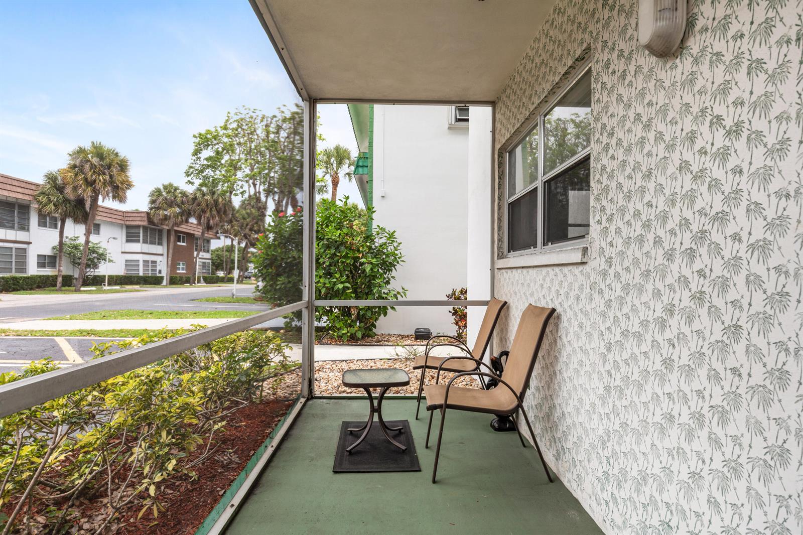A screened-in porch features two chairs, a small table, and patterned wallpaper — 2271 NW 48th Terrace # 111, Lauderhill FL 33313, LAUDERHILL, FL