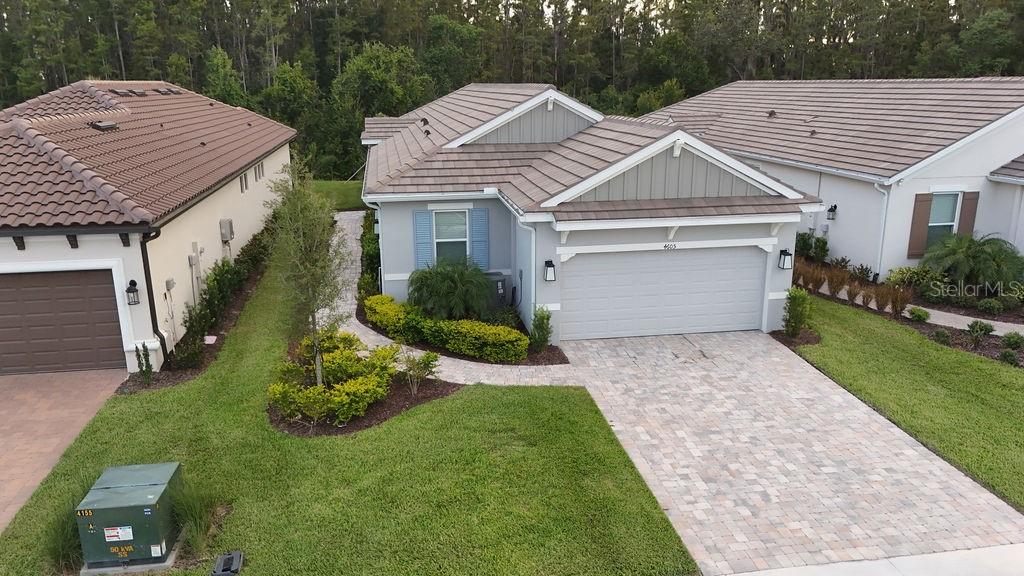 An aerial view shows a suburban house with a paved driveway and a tiled roof — 4605 ROSATTI ROAD, WESLEY CHAPEL, FL